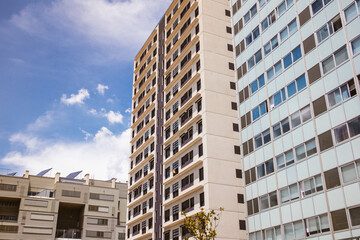 A grey and yellow facades of modern multistory residential buildings, houses from a bottom. Home details, architecture exterior low angle view. Real estate investment, housing. Downtown horizon.