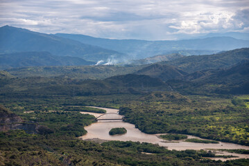 Aerial view of an iron bridge that crosses a river in a Colombian landscape