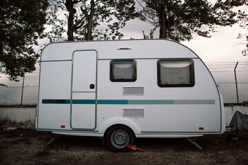 Holiday motor caravan at park camping site. Housing type vehicle is parked on a street in gloomy...