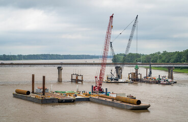 barges with cranes and pile driving equipment at a construction of a bridge over the Mississippi River at Chain of Rocks above St Louis