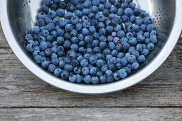 Freshly picked blueberries in a wooden bowl. Juicy and fresh blueberries. Blueberries on a wooden background. Blueberries are an antioxidant. The concept of healthy