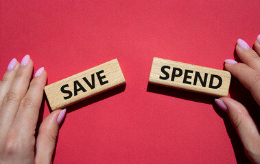 Save or Spend symbol. Concept word Save or Spend on wooden blocks. Businessman hand. Beautiful red background. Business and Save or Spend concept. Copy space