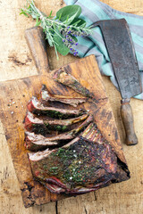 Traditional barbecue venison ribs with herbs and spice  served as top view on a rustic wooden board...