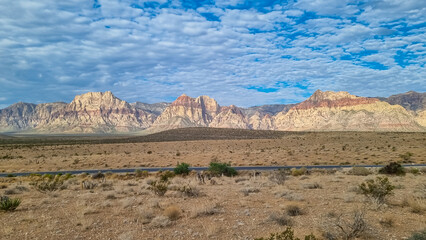 Barren landscape with view of limestone peaks Mount Wilson, Bridge and Rainbow Mountain of Red Rock Canyon National Conservation Area in Mojave Desert, Las Vegas, Nevada, United States. Remote hiking