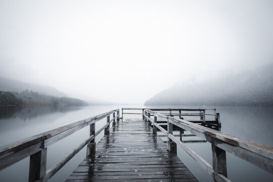 Fototapeta foggy winter pier on quiet lake