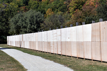 Wooden fence in a park with trees in the background in autumn