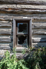 Window of old wooden house with broken glass and broken glass.