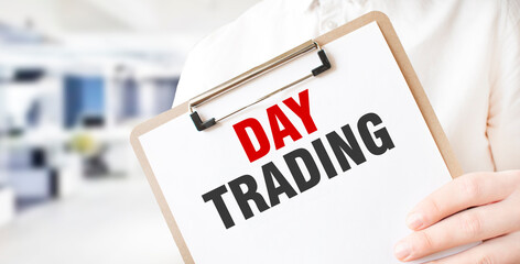 Text day trading on white paper plate in businessman hands in office. Business concept
