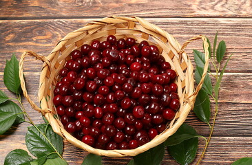 Summer cherry berries in baskets on a wooden background, harvesting in the village, healthy natural...