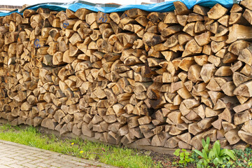 Wall of dry chopped firewood. Preparing for the heating season