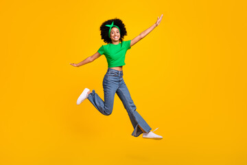 Fototapeta na wymiar Full size photo of excited energetic person jumping arms wings flying empty space isolated on yellow color background