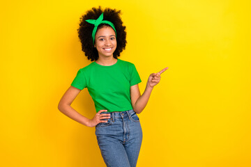 Photo of pretty charming lady wear green t-shirt hairband pointing finger empty space isolated yellow color background