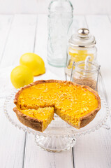 Traditional French tart au citron cake served as close-up on a plate on a wooden table