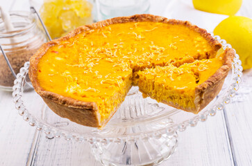 Traditional French tart au citron cake served as close-up on a cake plate on a wooden table