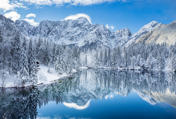 Fototapeta na wymiar Magic and emotions of the Fusine lakes after the snowfall. Winter dress magic. Tarvisio. Top view
