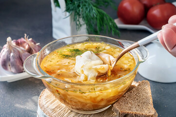 Soup is a traditional Russian soup. Cabbage, potato and meat soup in a transparent glass tureen. Traditional Russian and Ukrainian cuisine