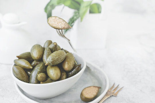 capers in white dishes on a light background. Pickled capers. Canned capers