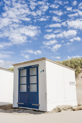 Fototapeta na wymiar Texel white beach storage huts next to the dunes