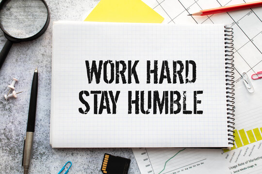 Word quotes of WORK HARD STAY HUMBLE on colorful memo papers with wooden background.