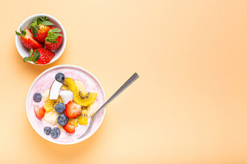 Healthy breakfast or dessert yogurt bowl with fresh banana, strawberry, blueberry, cocos, kiwi top...