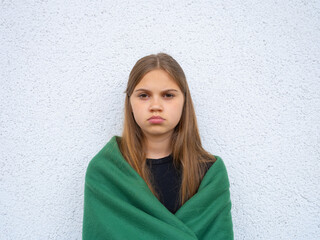 Portrait of a teenage girl looking at the camera. Young sad thinking curious child looks at the camera close-up. Face and eyes Serious contemplative child.