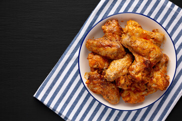 Homemade Rotisserie Chicken Wings with Smoked Paprika and Mayonnaise on a Plate, top view. Copy space.