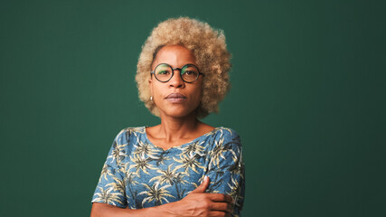 Beautiful girl in glasses, wearing a blue t-shirt attentively listens to someone and nods her head in agreement isolated on green-blue a  background