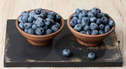 Ripe blueberries in a bowl on the table, healthy and tasty berry
