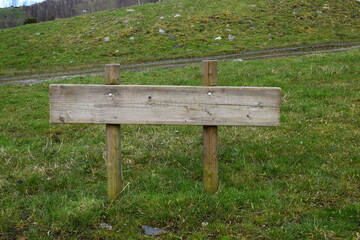 Empty wooden sign by the trail in the grass