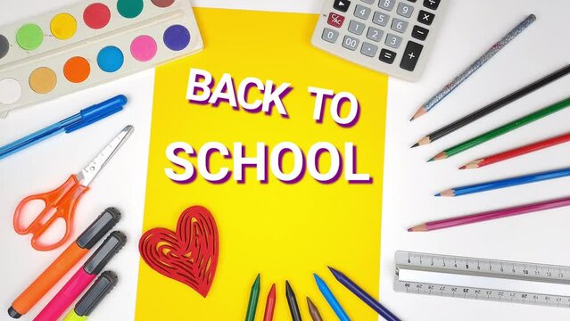 Back to school a man's hand open "Back to school". View of a red heart. Crayons, ruler, tempera and stationery for school. Top view, copy space.
