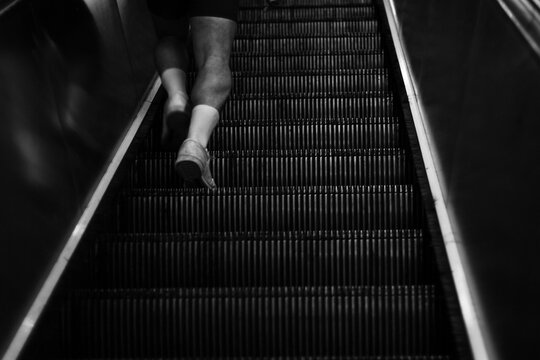 back view of man's calves with sport tennis and long socks on escalator
