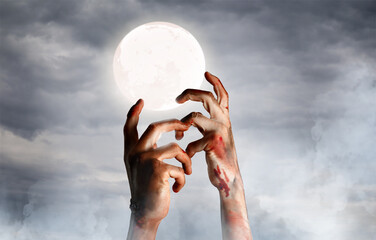 Hands of zombie on dark background