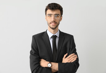 Young businessman in suit on light background