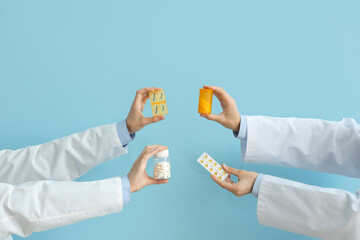 Female doctor's hands with different pills on blue background