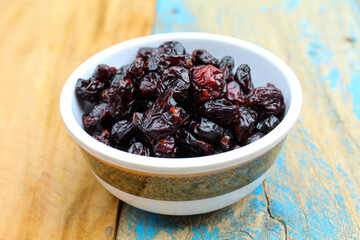 Dried Cranberry in a bowl on wooden background 