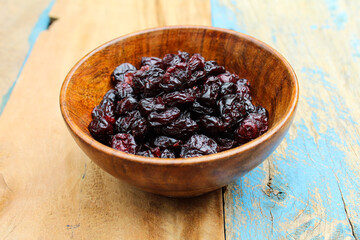 Dried Cranberry in a wooden bowl on old wooden background 