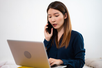 Asian woman using a laptop working long-distance at home