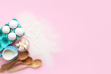 Composition with ingredients for preparing bakery and wooden spoons on pink background