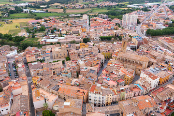 Fototapeta premium Scenic aerial view of small Catalan township of La Bisbal d Emporda overlooking Santa Maria church and fortified episcopal palace on summer day, Spain..