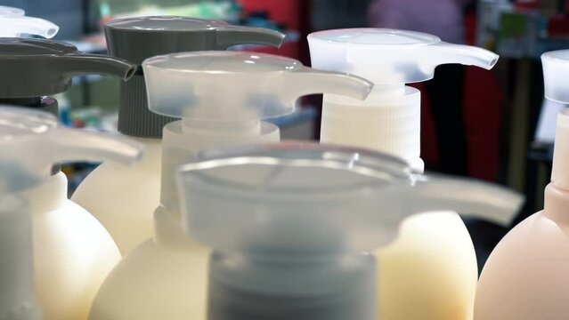 Bottles with liquid hand soap or hair balm in a cosmetics store shelf. Close up