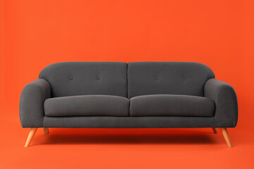 Cozy black sofa on red background