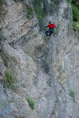 Climber placing safety nets to avoid falling rocks