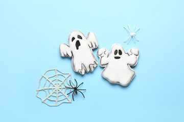 Tasty cookies in shape of ghost and web for Halloween celebration on blue background