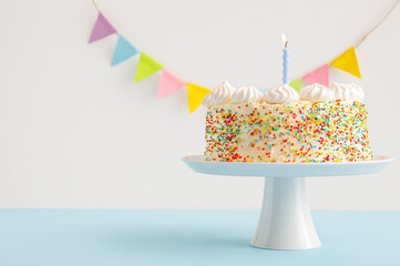 Stand with yummy Birthday cake and party garland on color background