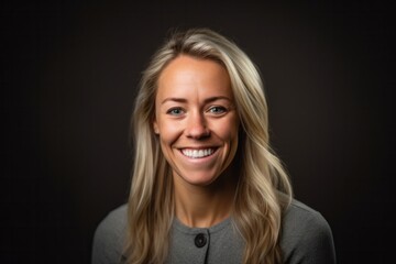Portrait of a beautiful blond woman smiling at the camera on a black background