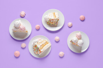 Plates with pieces of yummy Birthday cake and meringue on lilac background