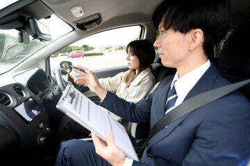 車の運転教習をする男性教官と女性生徒

