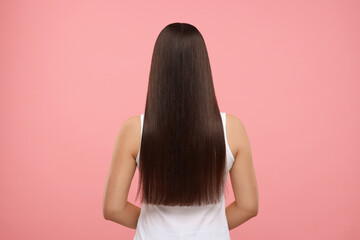 Obraz premium Woman with healthy hair after treatment on pink background, back view