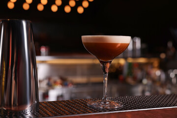 Glass of delicious Espresso Martini on bar counter. Alcoholic cocktail