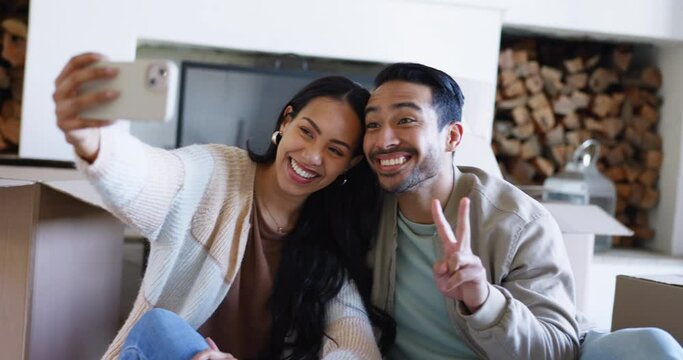 Happy couple, real estate and selfie in new home, photography or memory for moving in together. Man and woman or homeowners smile with boxes for photograph, picture or investment on social media